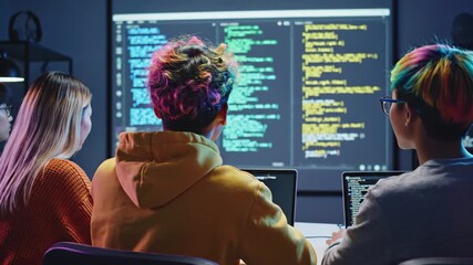 Young diverse programmers collaborate on a coding project, viewing code on a large screen in a tech office - Powered by Adobe