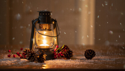 Warm glowing kerosene lantern with festive christmas decorations and falling snow creating a cozy winter holiday atmosphere Christmas Day
