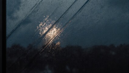 Rain-streaked window at night with blurred city lights.
