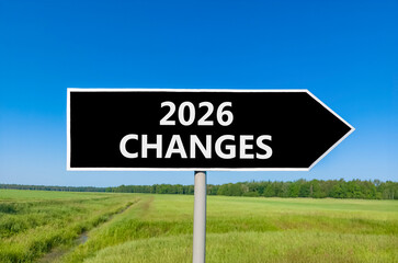 2026 Changes symbol. Concept words 2026 Changes on beautiful black road sign. Beautiful green grass field forest and blue sky background. Business and 2026 changes concept. Copy space.