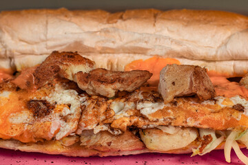 Long sandwiches with chicken breast, eggs, cabbage, cheese and dressing on plate