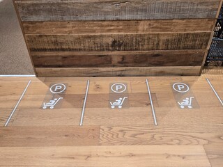 A high-angle view of a designated parking zone for baby strollers inside a shopping mall or retail store.