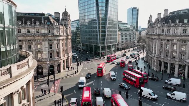Busy london street intersection with red doubledecker buses, modern skyscrapers, and historic buildings