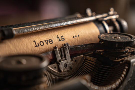 Close-up of Vintage Typewriter Typing "Love is…" on Brown Paper