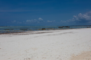 Beautiful white sand beach. Beach in Zanzibar. Sunny day. Blue sky. Colorful sea.