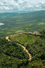 A winding road with a lush green hillside in the background