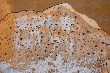 Detail of a wall with chiseled plaster, showing rough surface prepared for renovation to ensure new plaster adhesion.