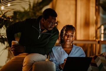 Colleagues collaborating on laptop late at night