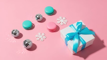 Obraz premium Brightly colored macarons and a festive gift box with a blue ribbon on a pink background