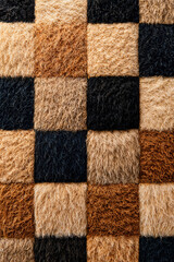 Checkerboard pattern with textured fur squares in brown and black  