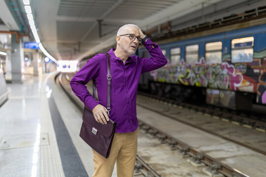 Senior man experiencing stress and headache at metro station