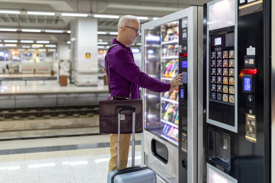 Traveler choosing drink from vending machine at station