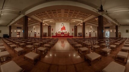 Panoramic View of a Buddhist Meditation Hall with Rows of Cushions and a Large Buddha Statue interior