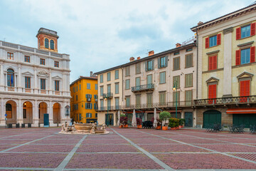 Colorful buildings and central fountain in Piazza Vecchia, Bergamo, Citta Alta, Lombardy, Italy. Italian old town square with medieval architecture. Travel destination in Italia