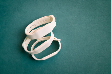 Functional gadget with an RFID bracelet.	White waterproof access key bracelets with a microchip on a dark turquoise background. Contactless silicone access key. 