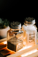 Salt and pepper shakers on a wooden tray in a cozy kitchen setting