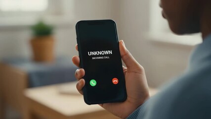 Over the shoulder view of a person holding a smartphone and answering an incoming call from an unknown number, showing the screen interface with accept and decline buttons before answering - Powered by Adobe