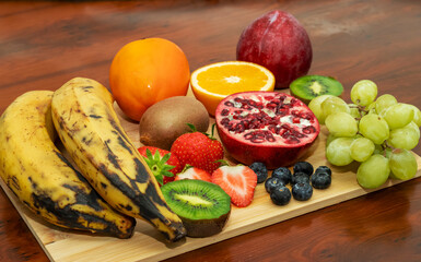 Diverse Selection of Colorful, Healthy Fruits Arranged on a Light Wooden Board
