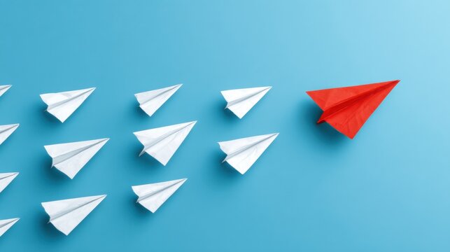 Red paper airplane leads white planes forward