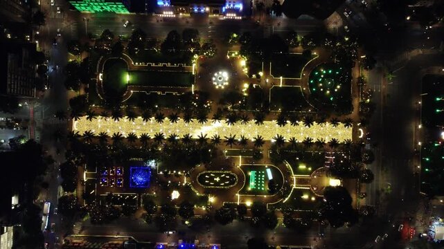 Descending drone zenith shot of Pra&ccedil;a da Liberdade at night, glowing with Christmas lights and festive decorations, capturing the vibrant holiday atmosphere in Belo Horizonte.