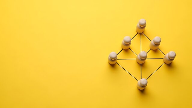 Abstract network concept using wooden figures arranged on a vibrant yellow background