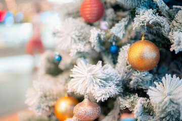 Closeup snowy Christmas tree decoration,red,gold,silver ornament with bokeh background. Perfect holiday sales, winter celebration, festive seasonal promotions, marketing, shopping with copy space