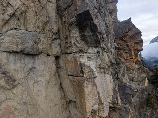 Rugged Mountain Cliff Face Along a Peak in BC, Canada With Cloudy Sky