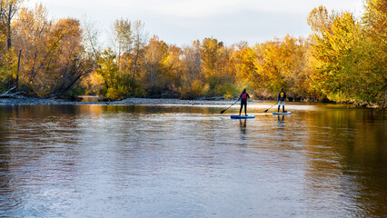 Water boarders in the Boise River on an autumn day