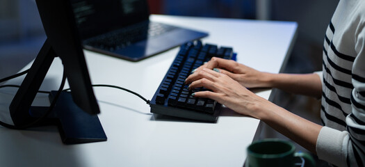 Hand of softtware programmer typing code on keyboard. Computer engineer working at desk in the office. Programming application, review data, research information. AI deep learning machine innovation
