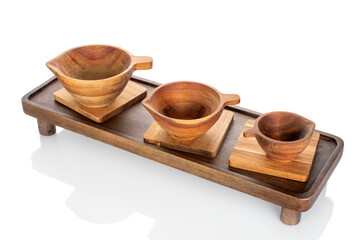 Wooden kitchen table with wooden cups isolated on white background, close-up.