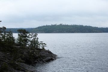 quiet coast with distant island, peaceful rocky coast with serene lake and remote island scenery