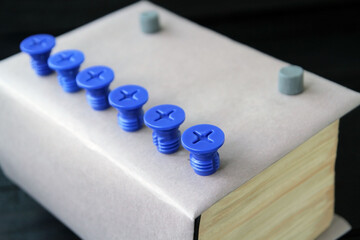 Naklejka premium Concept: a book as a key to knowledge, a thick paper book on an old dark wooden table. Books as a reservoir of fundamental scientific knowledge, books as the basis of education and enlightenment.