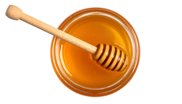 Overhead view of a jar filled with golden honey, a wooden dipper resting inside
