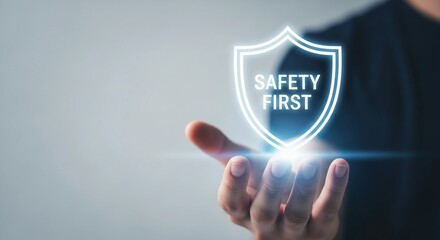 Safety first shield floating over hand, symbolizing protection.