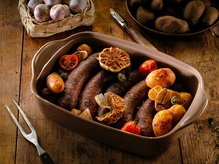 Savor the warmth of rustic Romanian food with juicy pork sausages paired with golden potato wedges, roasted alongside garlic and herbs for a delightful winter meal at home