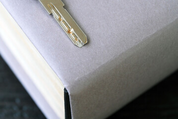 Concept: a book as a key to knowledge, a thick paper book on an old dark wooden table. Books as a...