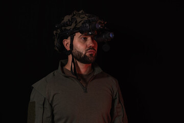 Portrait of bearded special forces soldier wearing helmet with night vision goggles isolated on black background for military concepts