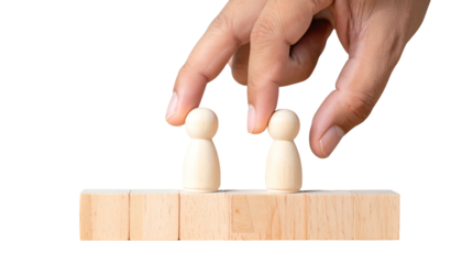 Hand placing small wooden figures on a wooden block, showcasing concept of control