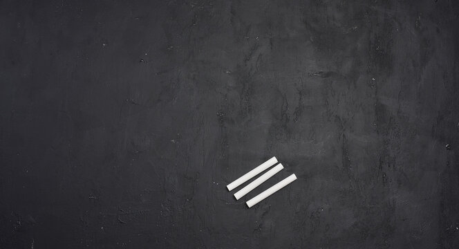 An empty black chalkboard and white chalk. Space for writing. - Powered by Adobe