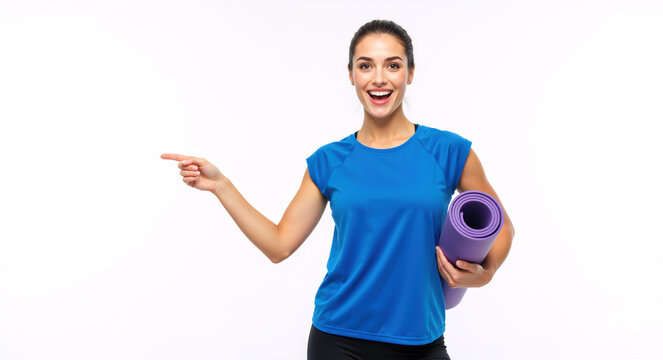 Happy fitness woman with a yoga mat pointing at copy space. Cheerful female athlete in sportswear isolated on a white background