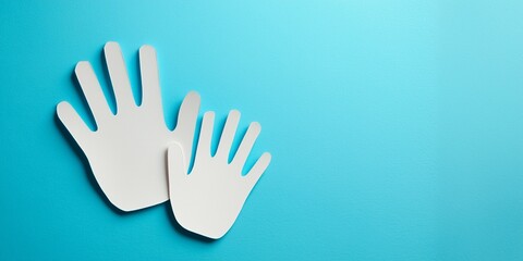 Obraz premium Top view paper cut art of parent and child hands on clean blue background, free space for text