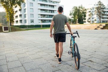 Man walking with bicycle in urban residential area
