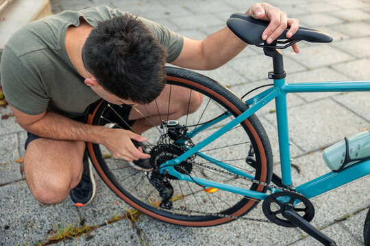 Young man adjusting bicycle gears for outdoor cycling