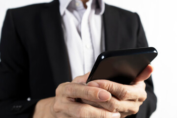 Businessman in black suit standing holding mobile phone to view work data and check work
