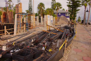 Active Construction Site With Signage, Rebar, and Wooden Forms in Early Stage Building. In St. Pete Beach, FL. Daylight highlights ongoing development, urban growth, and the sense of industry and prog