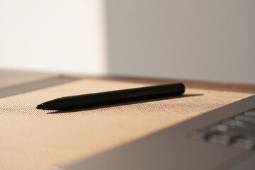 Slim Pen Close Up on Top of Laptop with a Wooden Surface and Simple Elegant Design on Work Concept for Writing 150 Characters