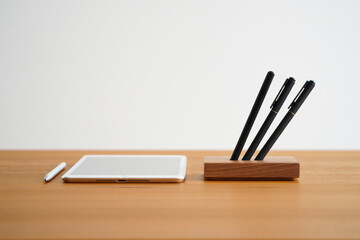 Wooden Pen Holder with Three Pens and Tablet Device on Wooden Table for Workspace or Office Desktop Organization with Minimalist Style