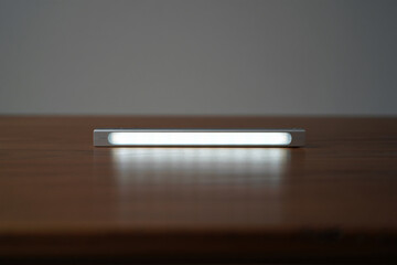 Sleek minimalist light bar on brown wooden table simple and efficient illumination for modern workspace or home office organization