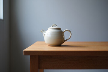 White ceramic teapot on wooden table for tea break time and coffee shop design kitchenware equipment with elegant simplicity in the room