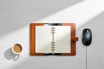 Blank Opened Notebook Surrounded by Coffee Mug and Mouse On Wooden Desk In Sunlight Offering Space For Creative Work And Inspiration